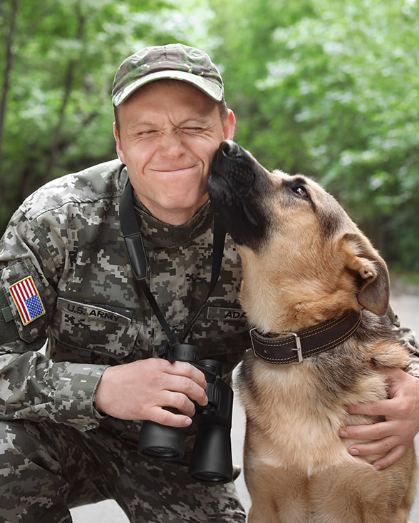 Man in military uniform with German shepherd dog, outdoors