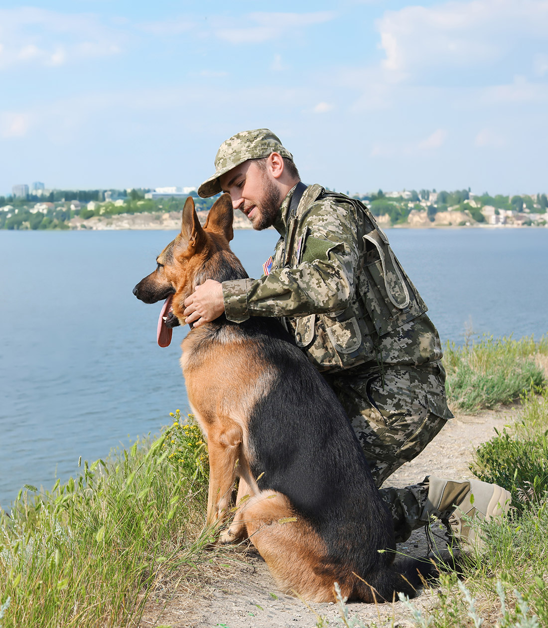 Man in military uniform with German shepherd dog outdoors